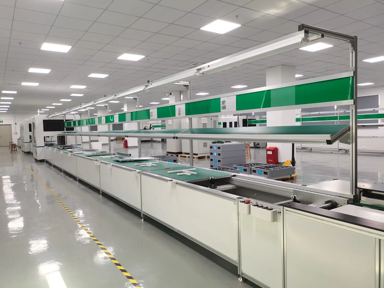 The assembly line: a full-length conveyor with anti-static worktops and component trays