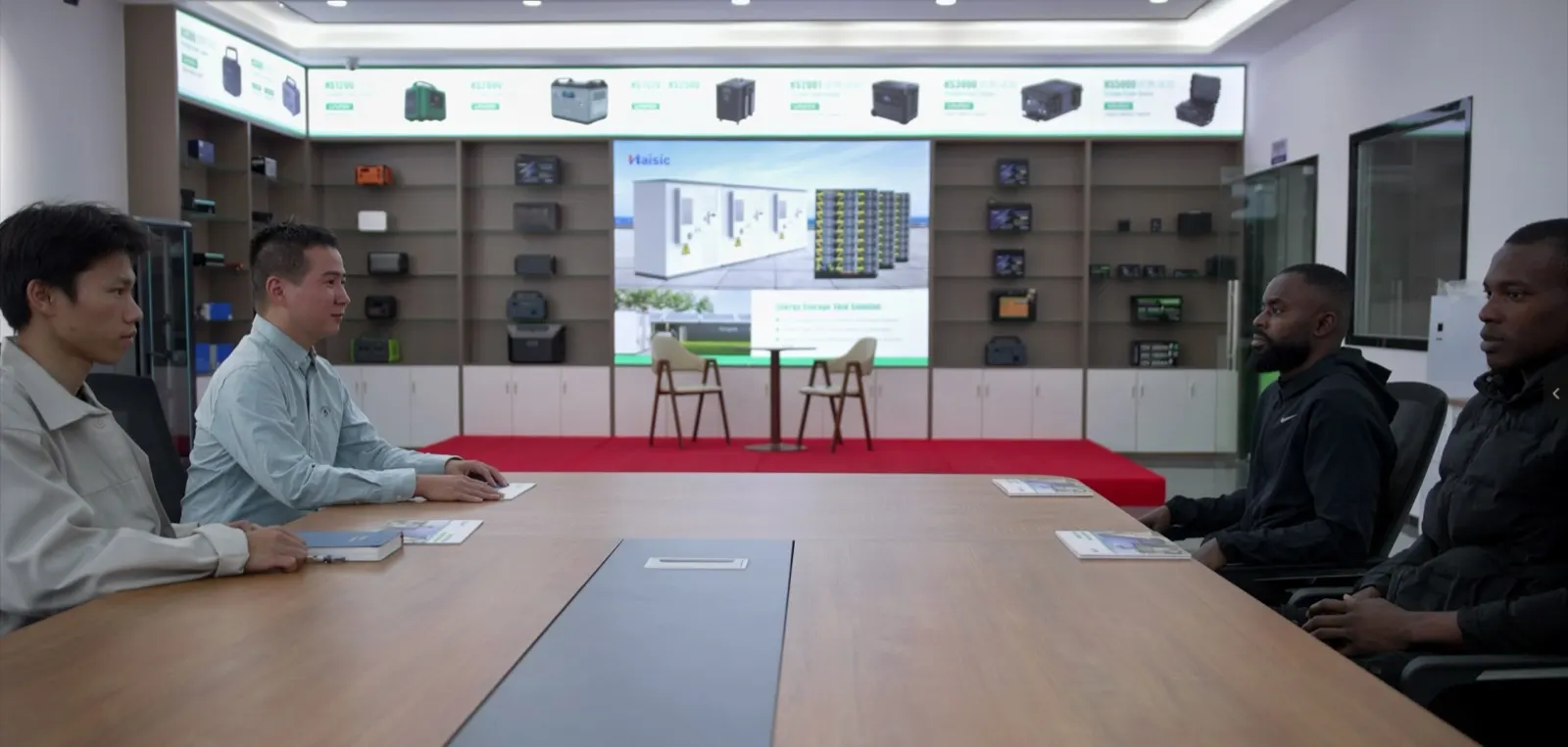 The Nigerian team meeting Shenzhen Haisic engineers in the product showroom, the energy-storage skid solution on the screen behind them