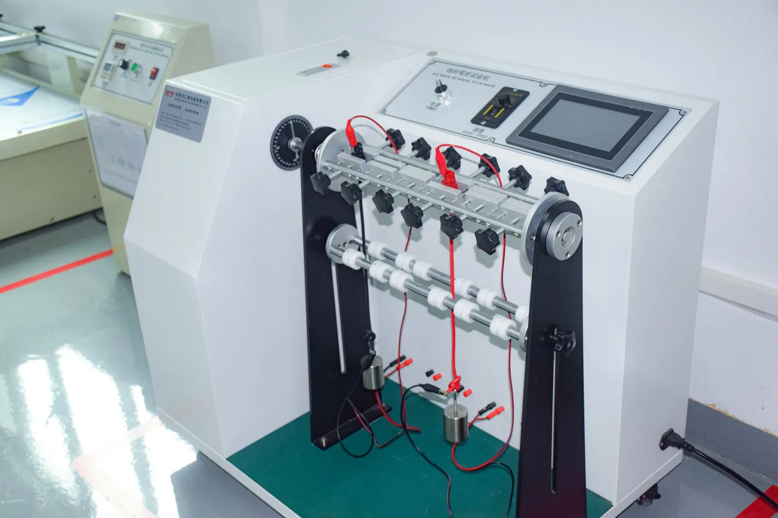 A wire bending and swing tester, measuring how long a cable survives being flexed under load