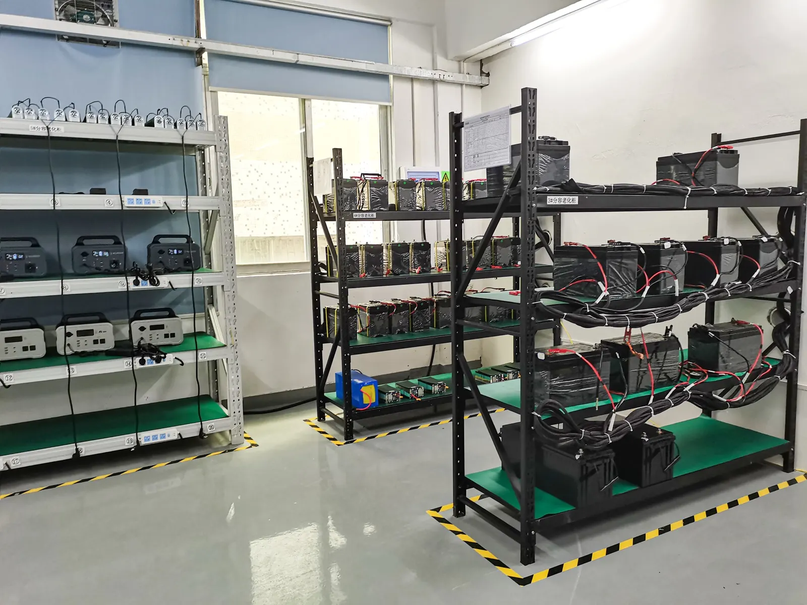 Capacity-grading and ageing cabinets, with batteries and portable power stations on numbered test racks